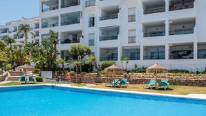 A multi-story hotel with a swimming pool, outdoor seating, and tropical landscaping. - Miraflores Refurbished by Alfresco Stays (Mijas Costa)