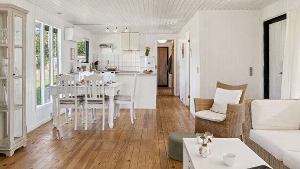 A spacious living area with a dining table and chairs, a wicker sofa, and a white coffee table. - "Lavrans" - 1km from the sea by Interhome (Ebeltoft)