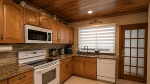 Une cuisine avec des meubles en bois, un four à micro-ondes, une cuisinière et un lave-vaisselle.