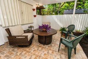 A patio with wicker furniture, a round table, and potted plants. - House In The Heart of Miami (Miami)
