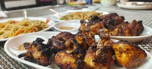 Savor a delicious meal at this dining area, where guests can enjoy a variety of dishes, including grilled chicken and noodles.