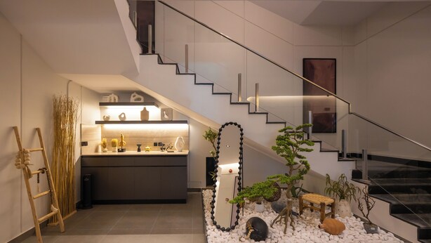 A modern kitchen with a built-in island, a staircase, and a small indoor garden. - Arjaan Park Al Shifa (Riyadh)