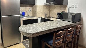 A compact kitchen with a stainless steel refrigerator, a microwave, and a coffee maker. - Ocean front resort 2-bedroom condo in charming Mazatlán with AC, WiFi (Mazatlán)