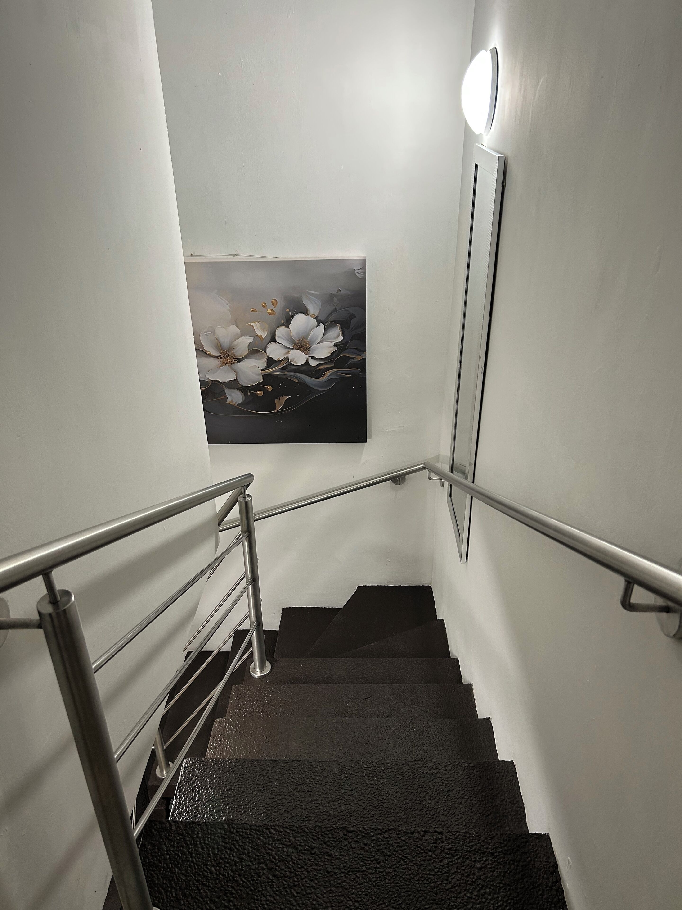 A staircase with metal railings and a wall-mounted light fixture.