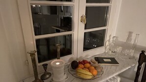 Eine Küchenarbeitsplatte mit Obstschale, Kerze und Buch.