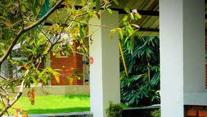 An outdoor dining area with a table set for two, featuring a plate of food and a wine glass. - NATURALIZA (Dambulla)