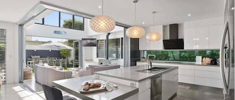 Una cucina moderna con isola centrale, elettrodomestici in acciaio inossidabile e illuminazione a sospensione.