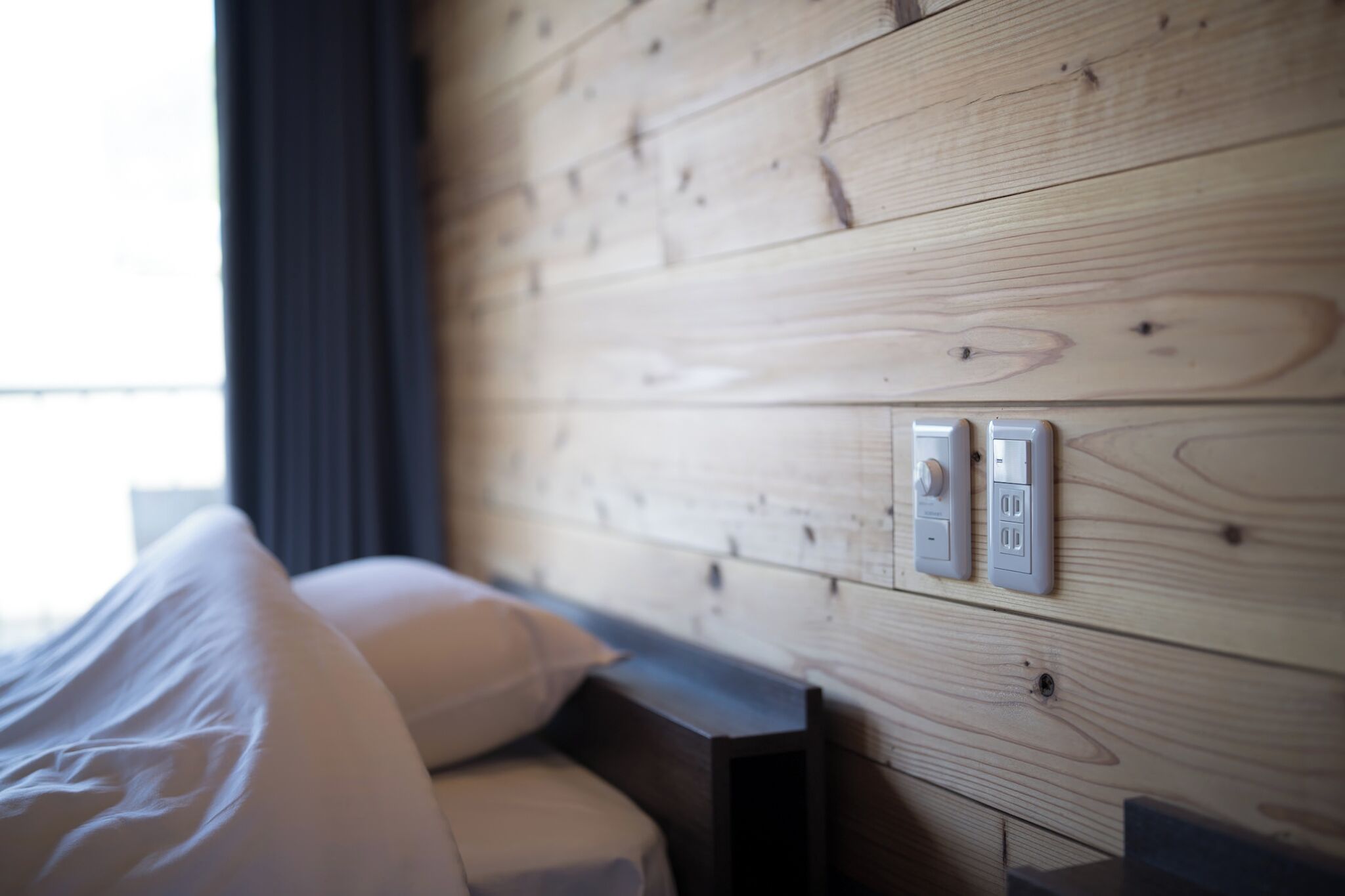 Een houten wand met een bed en een bedieningspaneel.