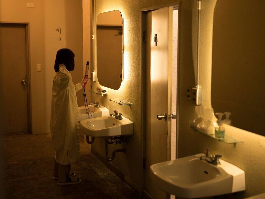 Ein schmaler Flur mit zwei Waschbecken und einem Spiegel.