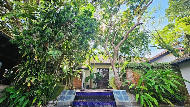 A pool area with steps leading into a building, surrounded by lush greenery. - Havelock Place Bungalow (Colombo)