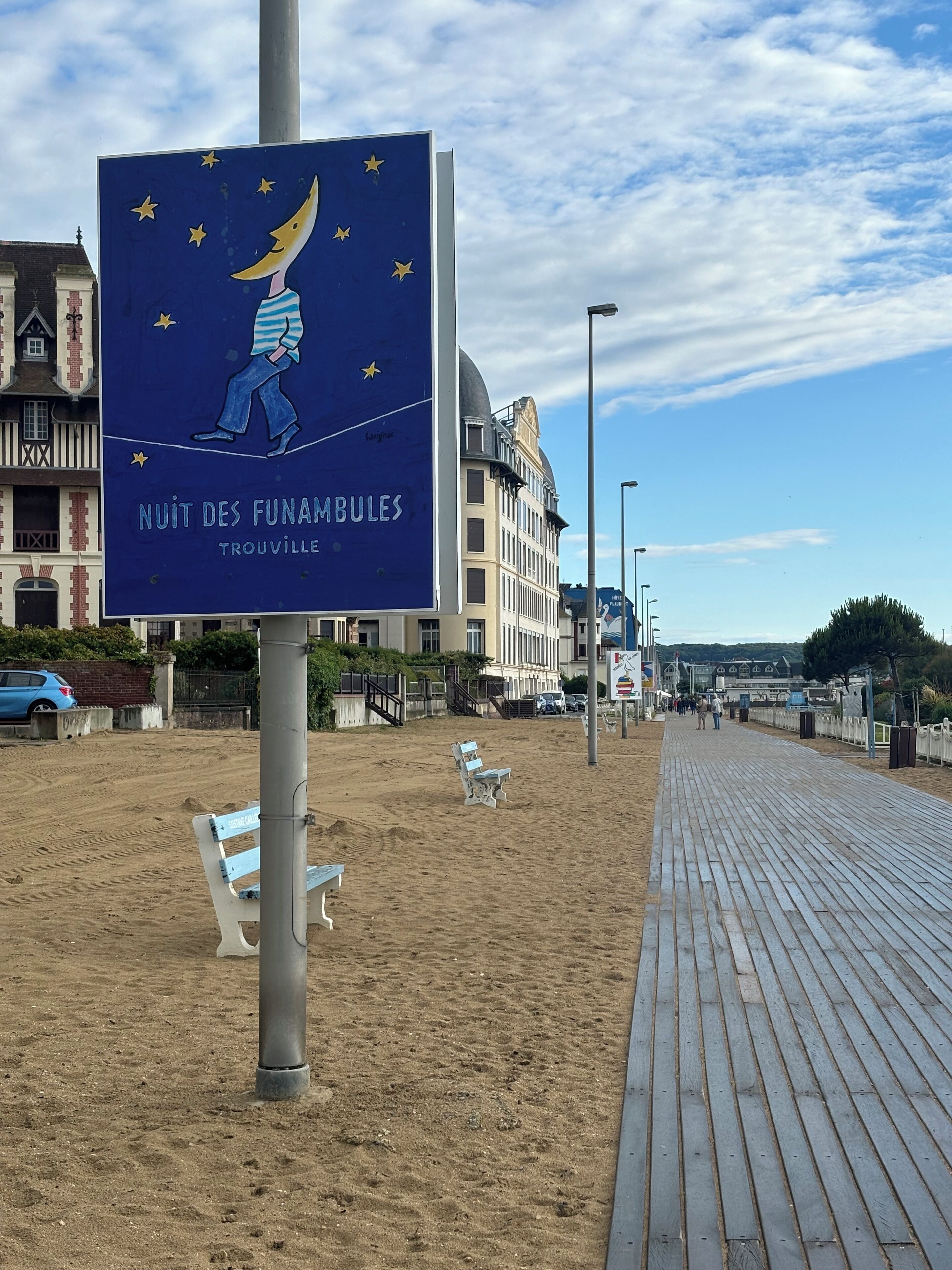 A beachside promenade with a sign advertising 'Nuit des Funambules' in Trouville.