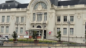 Un grande edificio storico con un ingresso ad arco ben visibile, con la scritta "Trouville Casino".
