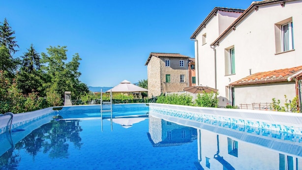 A swimming pool with clear blue water, surrounded by buildings with traditional architecture and a clear sky. - Cosy apartment for 4 guests with private pool, A/C, WIFI, TV, patio and pets allowed (Capannori)