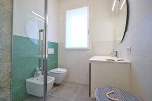 Chuveiro, secador de cabelo, bidê, toalhas de banho