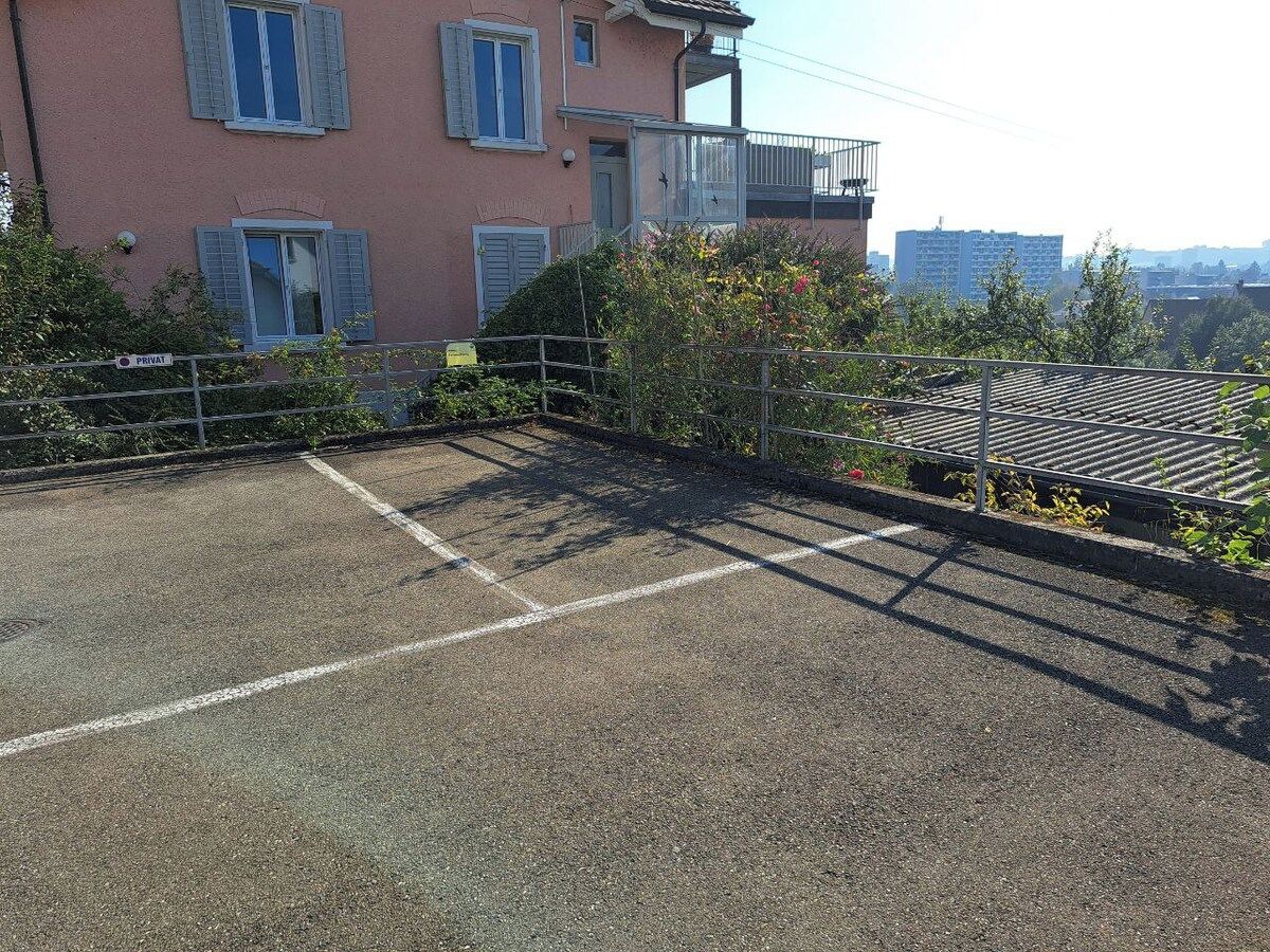 Ein Parkplatz auf dem Dach mit einem Gebäude im Hintergrund.