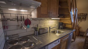 A modern kitchen with stainless steel appliances, wooden cabinets, and a tiled backsplash. - Valmorel, 2 rooms + mezzanine, 6 people, simple, pets, skiers (Valmorel)