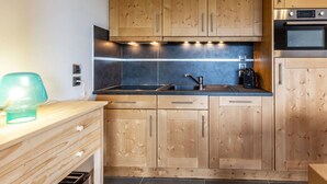 A modern kitchen with wooden cabinets, a stainless steel sink, and a built-in oven. - 3-room apartment with parking, Wi-Fi, pets allowed, 50m from slopes in Valmorel (Valmorel)