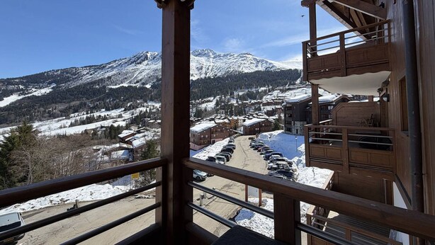A balcony with a view of a snow-covered mountain and a parking area. - 3-room apartment with parking, Wi-Fi, pets allowed, 50m from slopes in Valmorel (Valmorel)