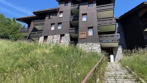 A modern multi-story building with a stone base and wooden upper floors.