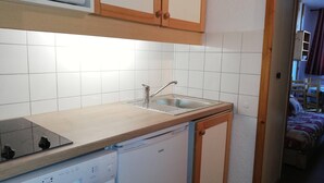 A compact kitchen with a dishwasher, a sink, and a stove.