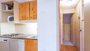 Une cuisine compacte dotée de meubles en bois, d’un lave-vaisselle Bosch et d’une cuisinière Bosch.