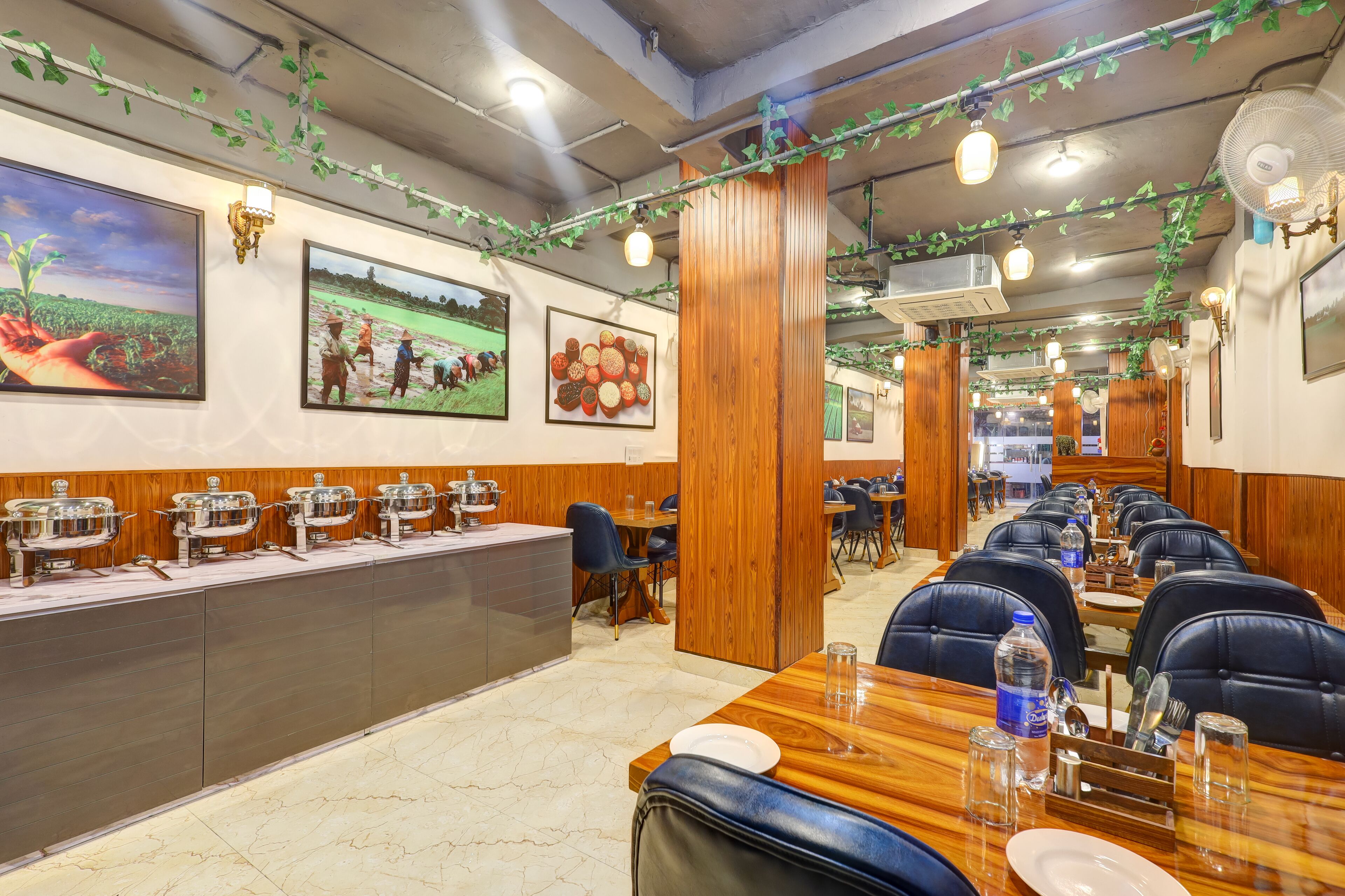 A restaurant with long communal tables, individual booths, and a buffet line.