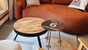 A cozy living room with a brown sofa, a round wooden coffee table, and a small side table with a coaster. - Beautiful apartment in Plagne Montalbert, near slopes with wifi and parking (La Plagne Montalbert)