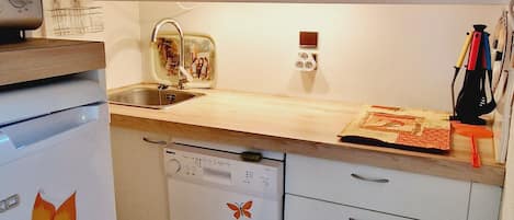 Une cuisine compacte équipée d’un four à micro-ondes, d’un évier et d’un lave-vaisselle.