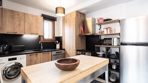 A modern kitchen with wooden cabinets, a stainless steel refrigerator, a microwave, and a dishwasher. - Cozy 2-room apartment in Plagne Montalbert, close to slopes and shops, with garage and wifi (La Plagne Montalbert)