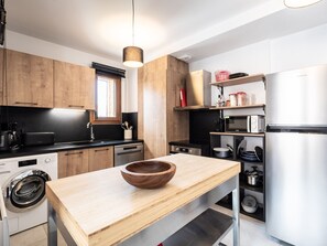 Una cucina moderna con mobili in legno, un frigorifero in acciaio inossidabile, un forno a microonde e una lavastoviglie.