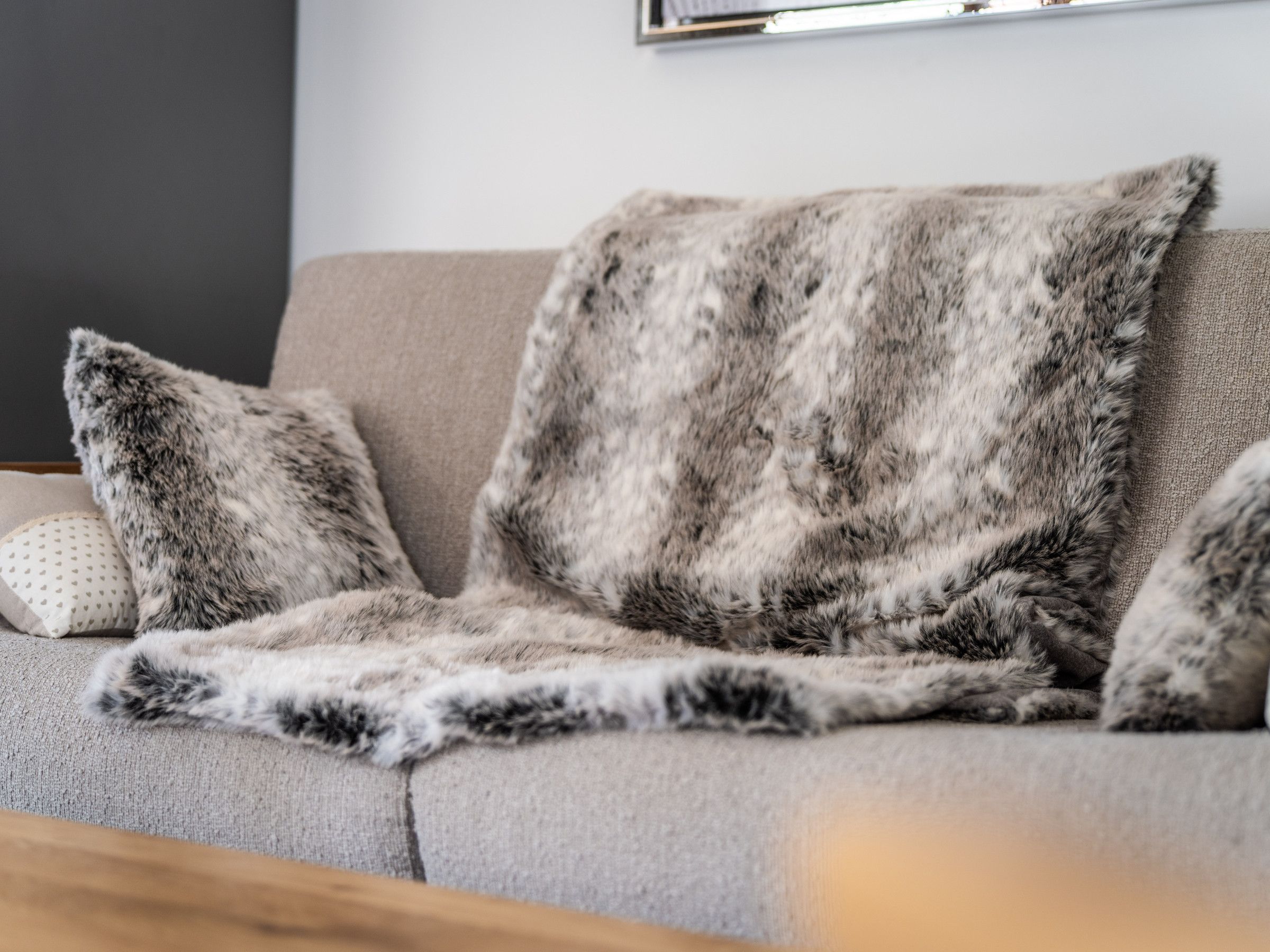 Ein Sofa mit Decke und Kissen.