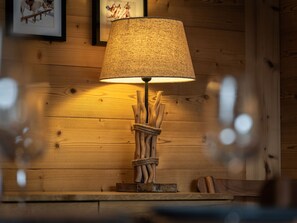 Een houten tafel met een lamp, voorzien van een lichtkap met structuur en een rustieke voet.