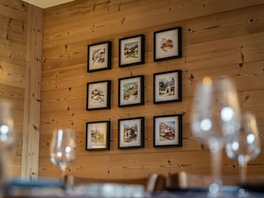 Een houten wand met ingelijste foto's van mooie landschappen.