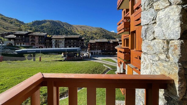 A hotel with a stone facade and a wooden balcony railing. - Valmorel: 32m² apt, ski-in/ski-out, balcony, ski locker (Valmorel)