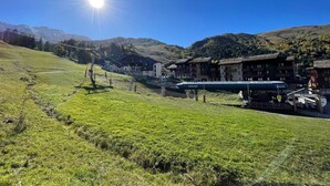 A mountain village with traditional buildings, a ski lift, and a clear blue sky. - Valmorel: 32m² apt, ski-in/ski-out, balcony, ski locker (Valmorel)