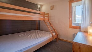 A bunk bed room with a ladder, a small desk, and a window with curtains. - Valmorel: 32m² apt, ski-in/ski-out, balcony, ski locker (Valmorel)