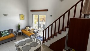 A spacious living area with a dining table, sofas, and a staircase. - Charaki Coastal Villa Retreat (Rhodes)