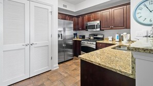 A modern kitchen with stainless steel appliances, wooden cabinets, and a granite countertop. - Coastal Hideaway: 3 Bdrm Oceanfront Condo 3rd Flr (North Myrtle Beach)