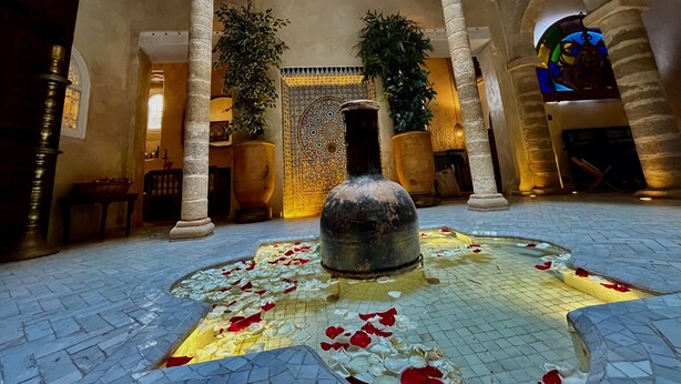 A spacious lobby with a fountain, columns, and potted plants. - RIAD MALAÏKA (Essaouira)