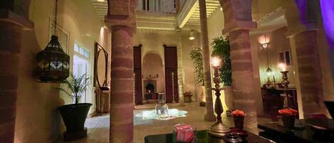 A spacious lobby with high ceilings, arches, and a fireplace.