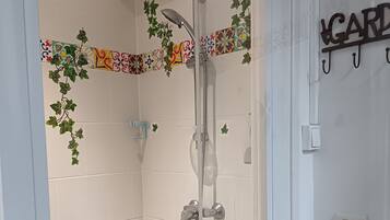 Een douche, handdoeken, zeep, shampoo