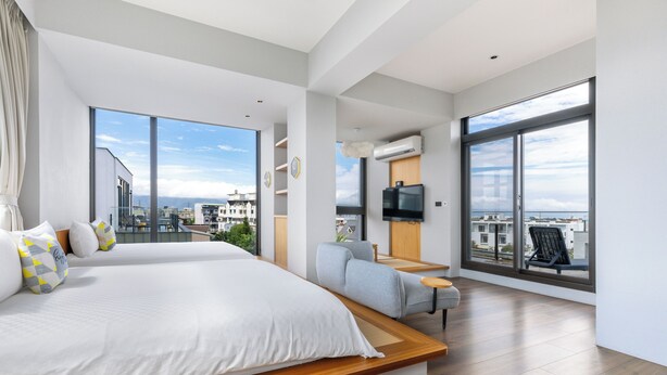 A modern bedroom with a large bed, a sofa, and a TV. It has large windows offering a city view. - Ning Xia Time Villa (Dongshan)