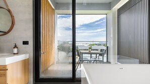 A modern bathroom with a large window, a round mirror, and a white bathtub. - Ning Xia Time Villa (Dongshan)
