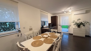 A modern kitchen with dark wood cabinets, a white countertop, and a built-in oven. - Modern House Gehrden contactless garden (Gehrden)