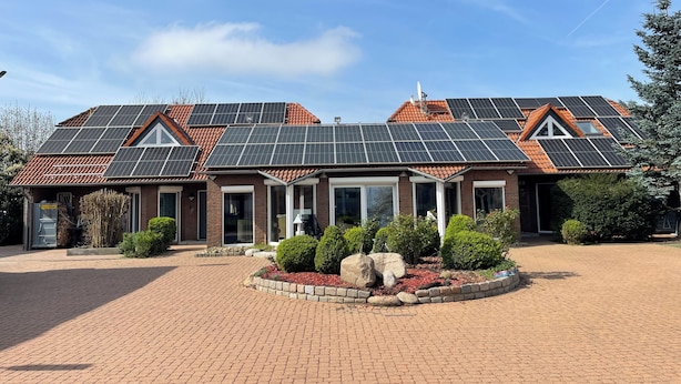 A house with a brick facade, multiple windows, and a solar panel roof. - Modern House Gehrden contactless garden (Gehrden)