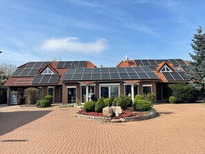 A house with a brick facade, multiple windows, and a solar panel roof. - Modern House Gehrden contactless garden (Gehrden)