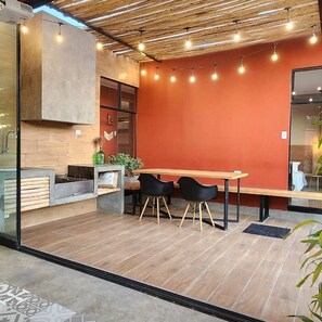 A modern interior with a wooden floor, a red accent wall, and a table with two chairs.