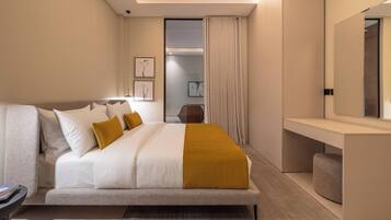 A modern hotel room with a large bed, a bedside table, a mirror, and a view of the hallway.