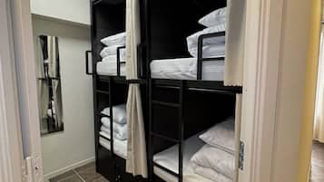 A room with bunk beds, a mirror, and a skylight.