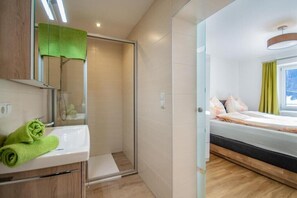 Chuveiro, secador de cabelo, toalhas de banho, papel higiênico